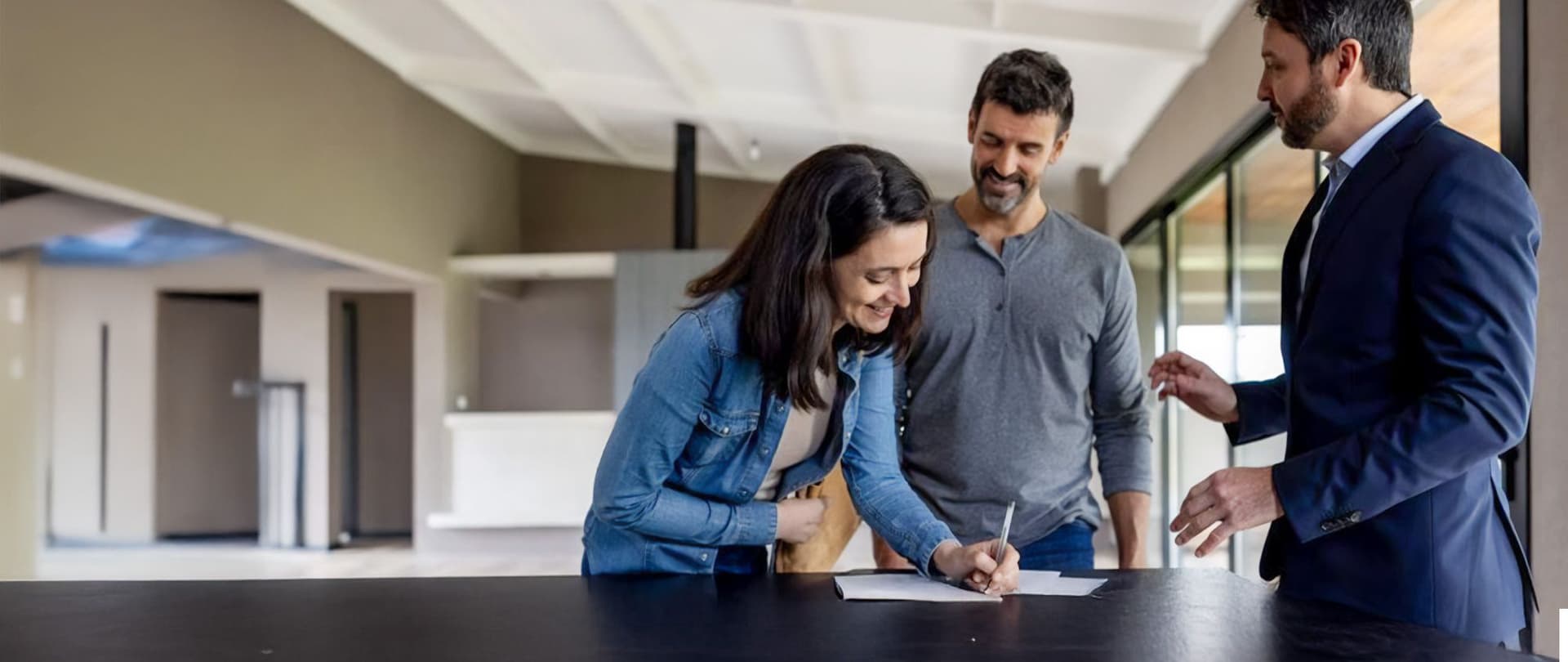 Eine Frau unterzeichnet das Wohnungsübergabeprotokoll in ihrer neuen Wohnung.